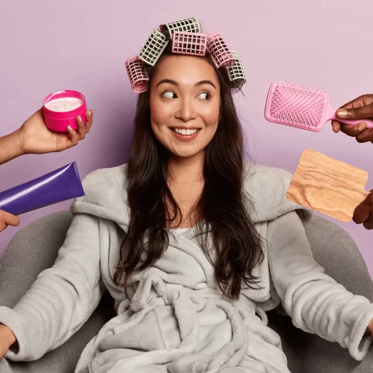 Mujer con tubos en el cabello y varios productos capilares alrededor, representando una rutina de cuidado personalizada